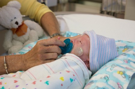 Preemie with hat in the NICU