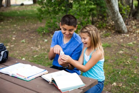 Boy and girl sitting at a table with books