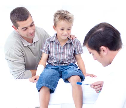 Father watches as physician gives young boy physical examination.